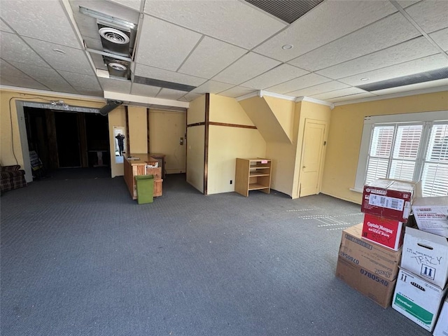 below grade area featuring a paneled ceiling, carpet, and visible vents