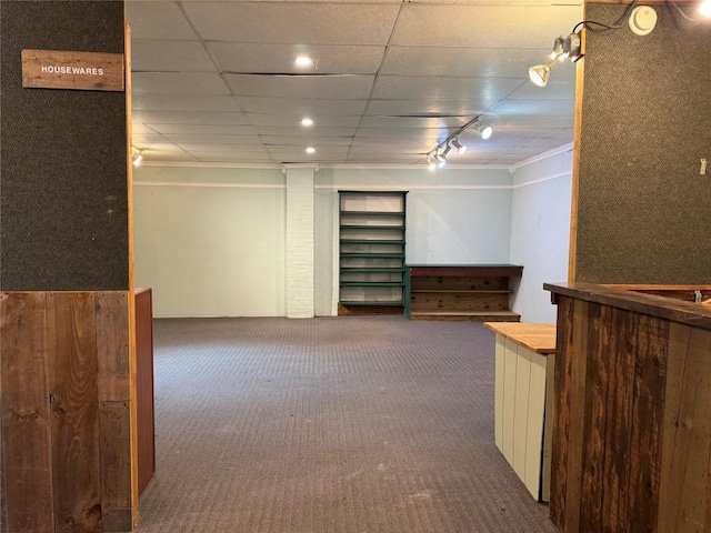 interior space featuring carpet, rail lighting, and a paneled ceiling