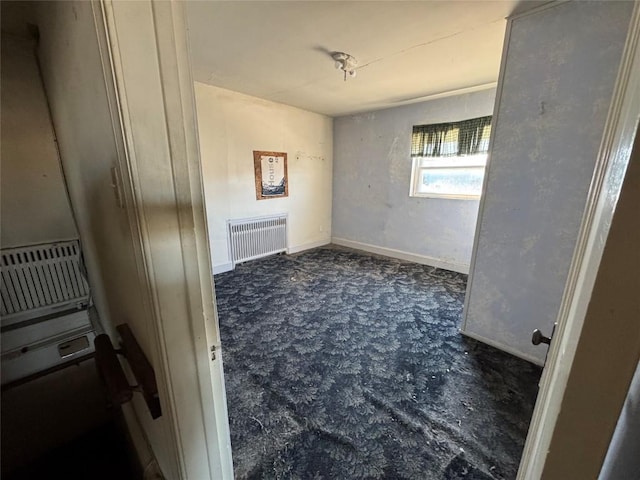 unfurnished room featuring baseboards and radiator