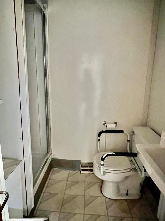 539 W 3rd St, Erie, PA 16507 - bathroom with a shower stall, toilet, and baseboards