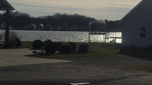 yard at dusk featuring a water view