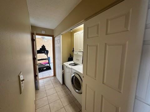 washroom featuring light tile patterned floors, cabinets, and washer and clothes dryer