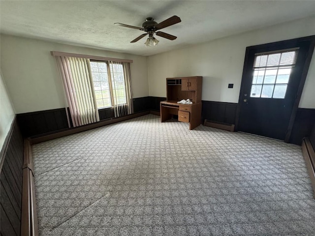 interior space with ceiling fan, a baseboard heating unit, and a textured ceiling