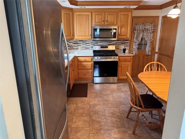 kitchen featuring pendant lighting, ornamental molding, appliances with stainless steel finishes, and tasteful backsplash