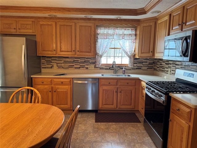 kitchen featuring sink, decorative backsplash, ornamental molding, and stainless steel appliances