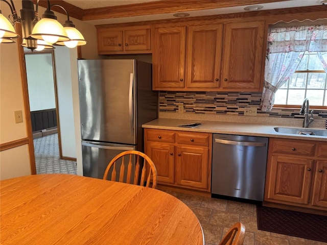 kitchen featuring sink, an inviting chandelier, backsplash, hanging light fixtures, and stainless steel appliances