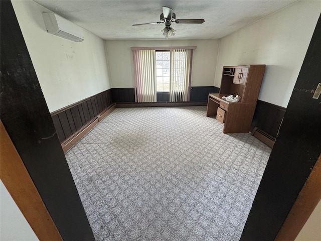 spare room with ceiling fan, a baseboard radiator, a wall mounted air conditioner, and a textured ceiling