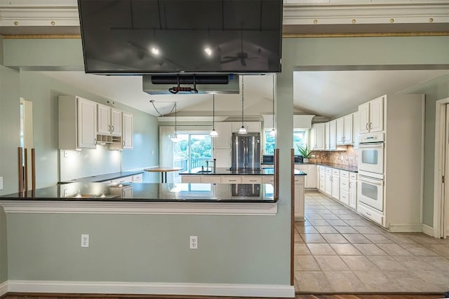 8730 Peffer Rd, Fairview, PA 16415 - kitchen featuring lofted ceiling, white double oven, dark countertops, a kitchen island, and tasteful backsplash