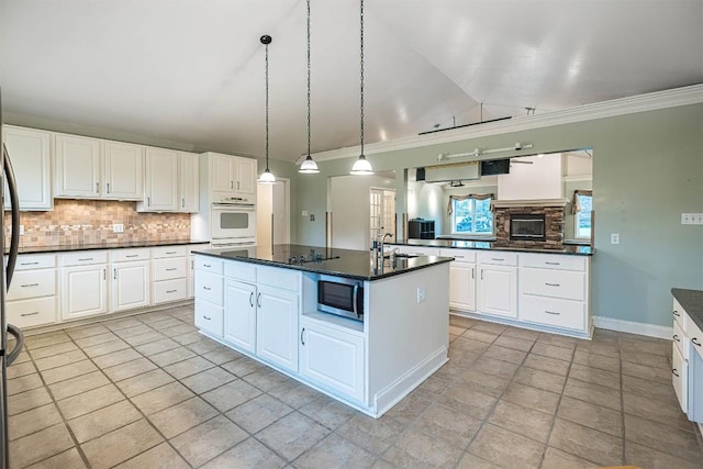 8730 Peffer Rd, Fairview, PA 16415 - kitchen with crown molding, vaulted ceiling, a sink, decorative backsplash, and stainless steel microwave