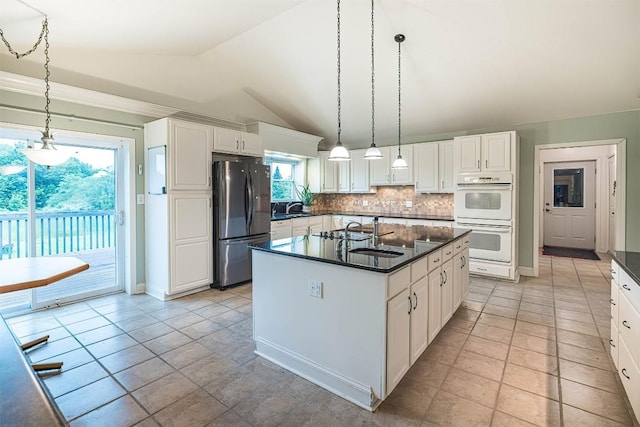 8730 Peffer Rd, Fairview, PA 16415 - kitchen featuring freestanding refrigerator, double oven, dark countertops, lofted ceiling, and tasteful backsplash
