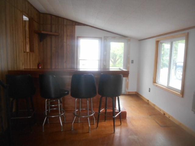 13615 W Ridge Rd, West Springfield, PA 16443 - kitchen featuring lofted ceiling, a breakfast bar area, baseboards, wooden walls, and open shelves
