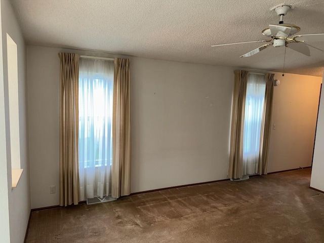 carpeted spare room featuring ceiling fan and a textured ceiling