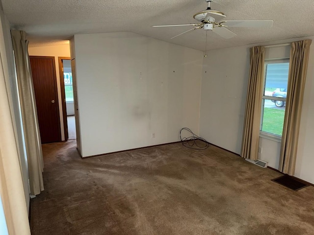 unfurnished room featuring dark colored carpet, a textured ceiling, ceiling fan, and lofted ceiling