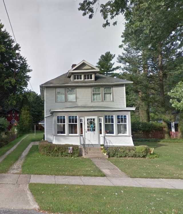 american foursquare style home featuring a front yard