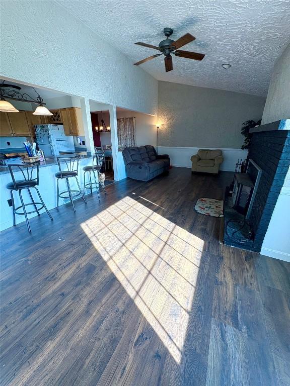 4224 Amherst Rd, Millcreek, PA 16506 - living room featuring a textured wall, wood finished floors, ceiling fan, a textured ceiling, and lofted ceiling