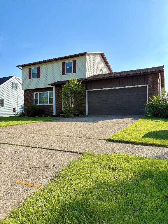 4224 Amherst Rd, Millcreek, PA 16506 - traditional-style home featuring asphalt driveway, brick siding, a garage, and a front yard