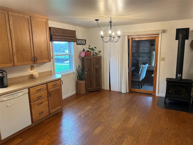 kitchen with dark hardwood / wood-style flooring, white dishwasher, decorative light fixtures, a chandelier, and a wood stove