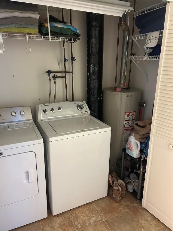 clothes washing area featuring washing machine and dryer and gas water heater