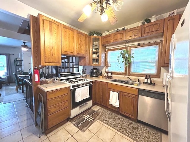 kitchen with ceiling fan, sink, white appliances, and light tile patterned floors