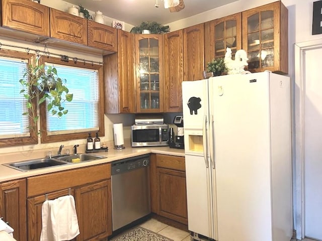 kitchen with sink, light tile patterned flooring, a wealth of natural light, and appliances with stainless steel finishes