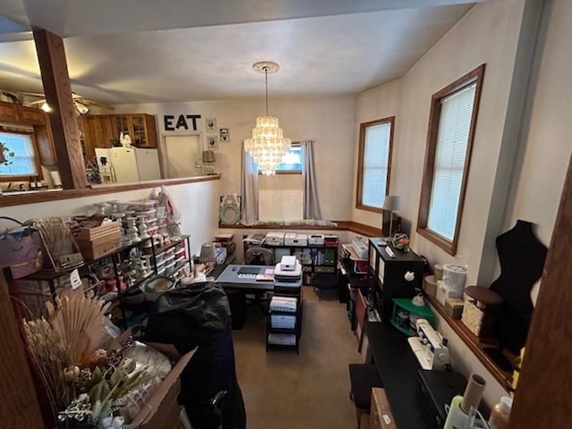 miscellaneous room with ceiling fan with notable chandelier and carpet flooring