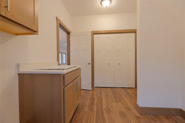 hall with light hardwood / wood-style flooring and a textured ceiling