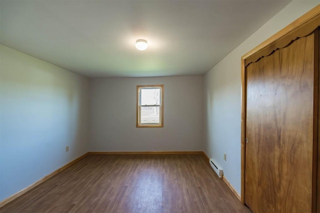 unfurnished bedroom featuring hardwood / wood-style flooring, a closet, and a baseboard radiator