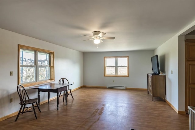 dining area featuring ceiling fan, dark wood-type flooring, and a baseboard radiator