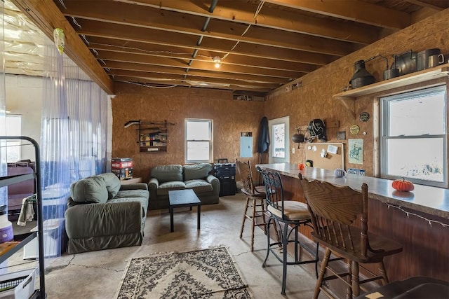 interior space featuring electric panel, a healthy amount of sunlight, and indoor bar