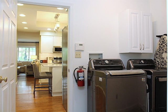 1351 Top Rd, Erie, PA 16505 - laundry area featuring wood finished floors, cabinet space, washing machine and dryer, and recessed lighting