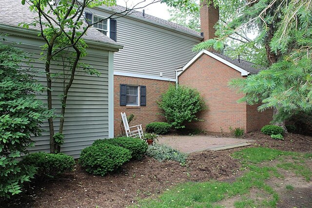 1351 Top Rd, Erie, PA 16505 - view of side of home with a chimney, brick siding, and a patio