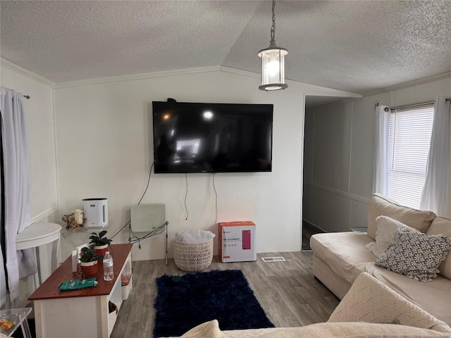 living area with lofted ceiling, crown molding, a textured ceiling, and wood finished floors