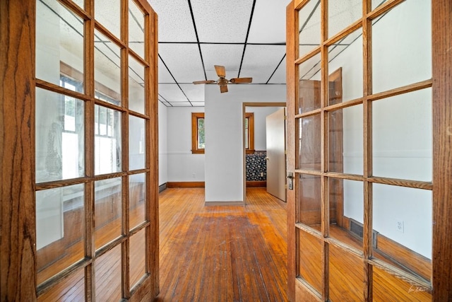 corridor featuring french doors, hardwood / wood-style flooring, and a drop ceiling