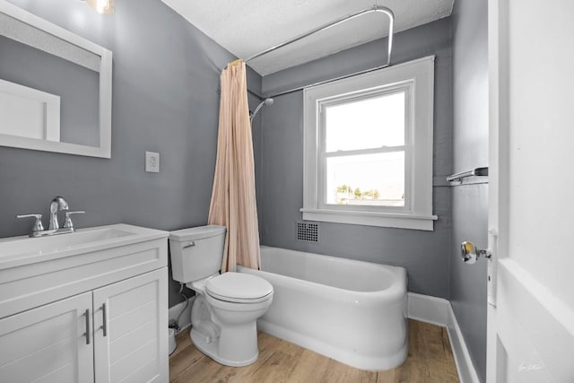 full bathroom featuring vanity, hardwood / wood-style floors, a textured ceiling, and shower / tub combo