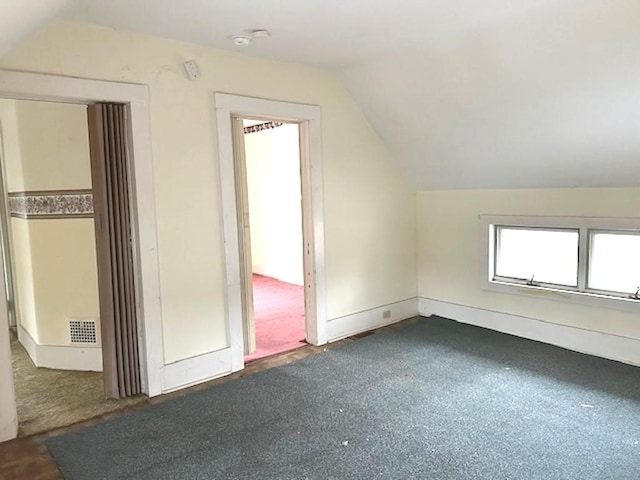 additional living space featuring visible vents and vaulted ceiling