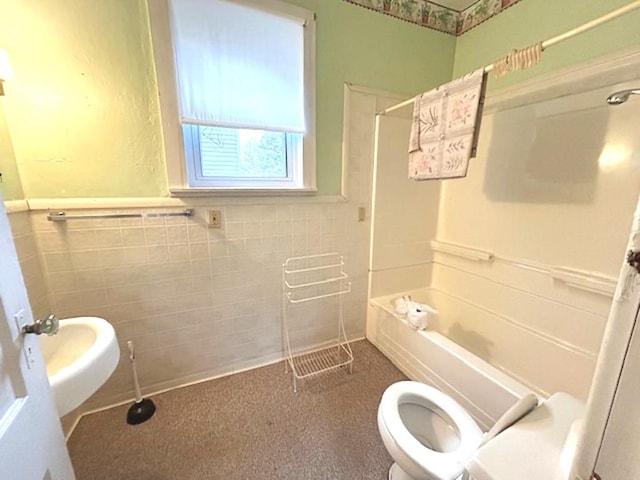 full bath featuring toilet, wainscoting, tile walls, and bathing tub / shower combination