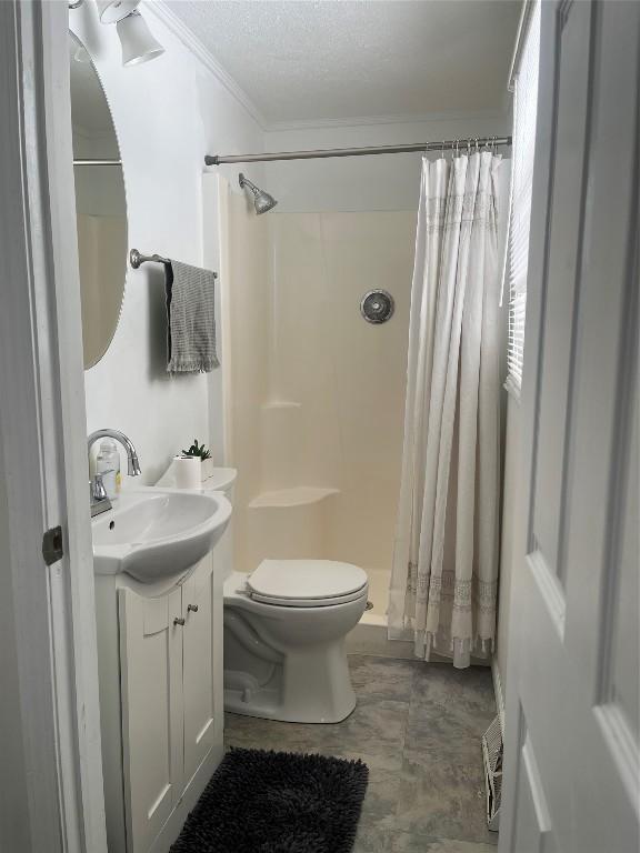 bathroom with crown molding, toilet, a shower stall, vanity, and a textured ceiling