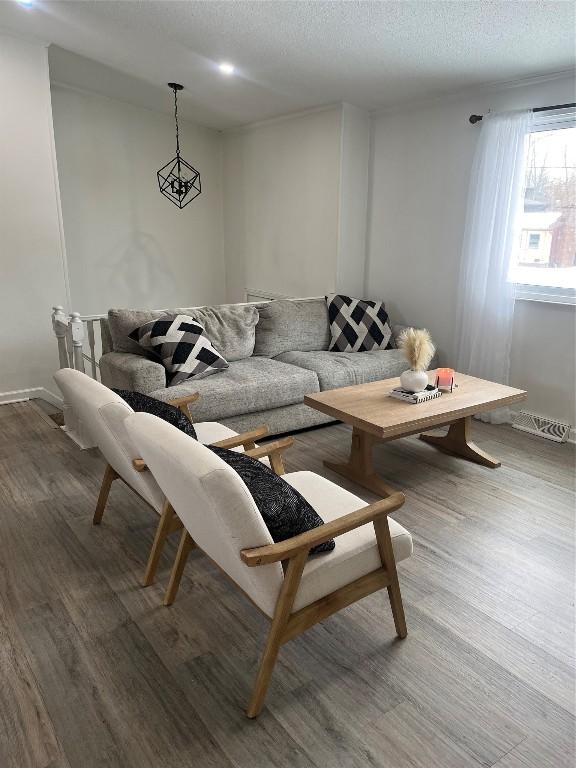 living area with a textured ceiling and wood finished floors