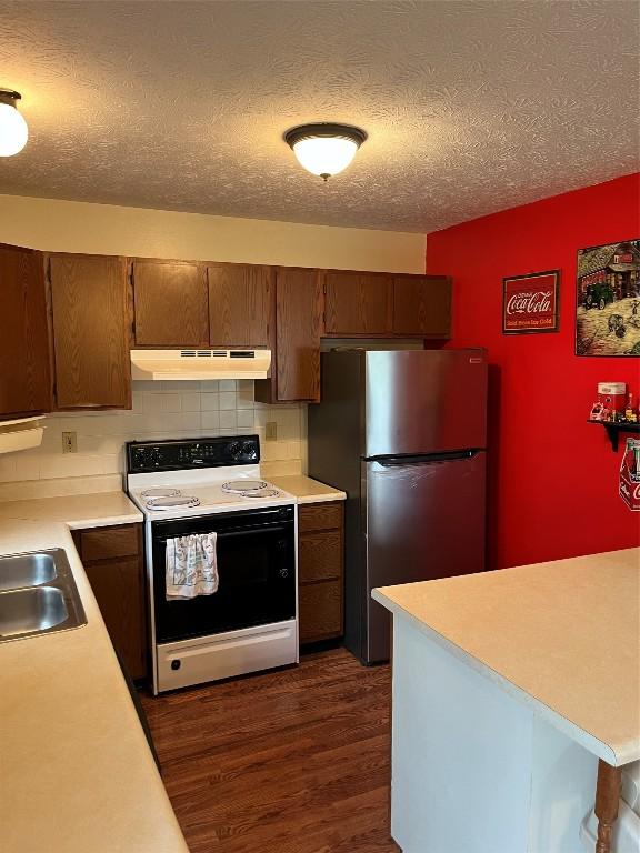 6915 Snodgrass Rd, Jamestown, PA 16134 - kitchen with range with electric cooktop, under cabinet range hood, freestanding refrigerator, light countertops, and dark wood-style floors