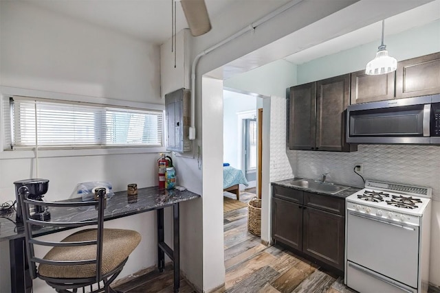 kitchen with sink, backsplash, electric panel, light hardwood / wood-style floors, and gas range gas stove