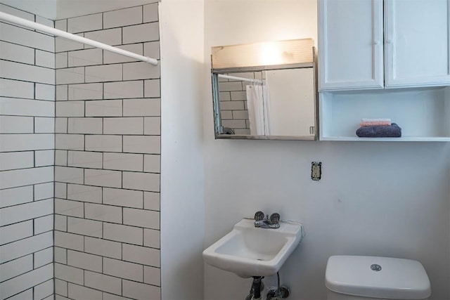 bathroom with sink, curtained shower, and toilet