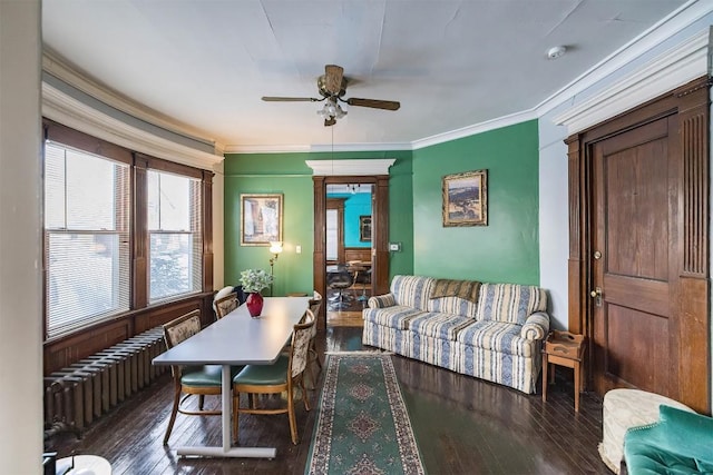 dining area featuring ceiling fan, ornamental molding, radiator, and dark hardwood / wood-style flooring