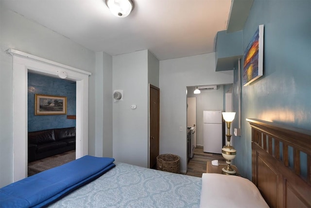 bedroom with a closet, dark hardwood / wood-style floors, and white fridge