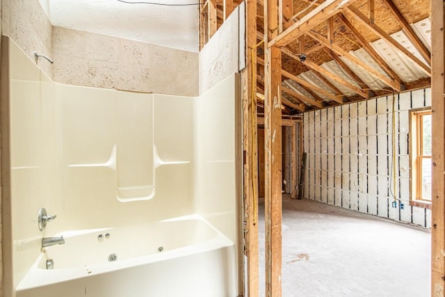 bathroom featuring shower / bathing tub combination and concrete flooring