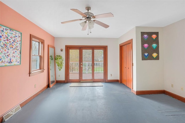 empty room featuring baseboards, a ceiling fan, visible vents, and plenty of natural light