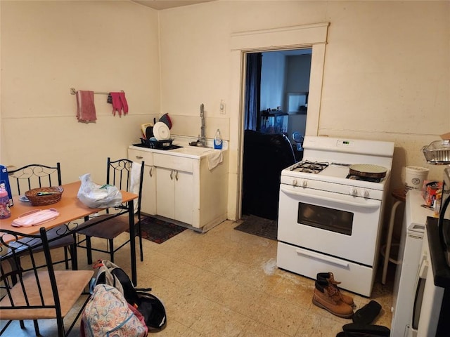 kitchen with white gas range oven and light floors