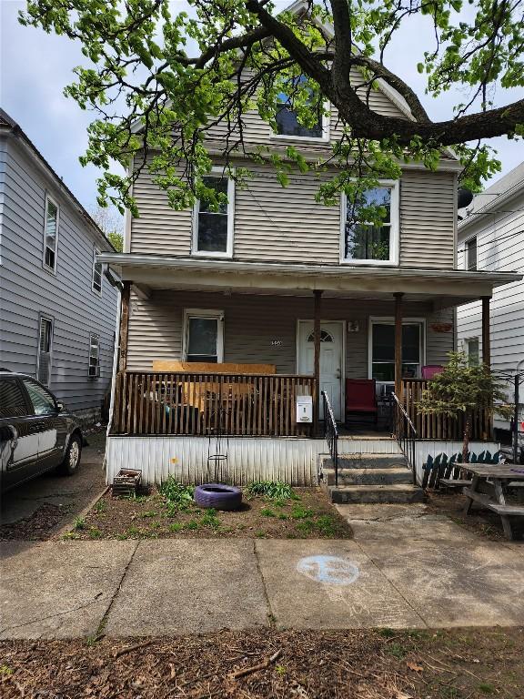american foursquare style home featuring covered porch