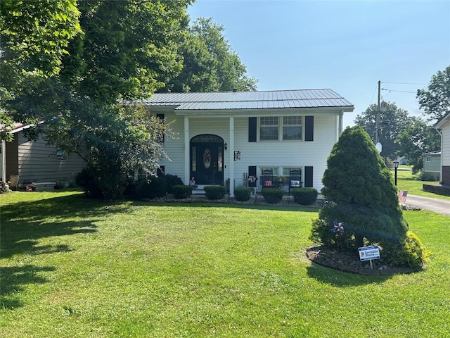 103 S Church St, Linesville, PA 16424 - split foyer home featuring a front lawn, covered porch, and a metal roof