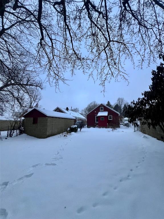 yard layered in snow with an outbuilding