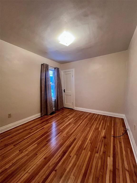 unfurnished room with hardwood / wood-style floors